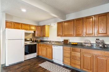 A kitchen with white appliances and wooden cabinets